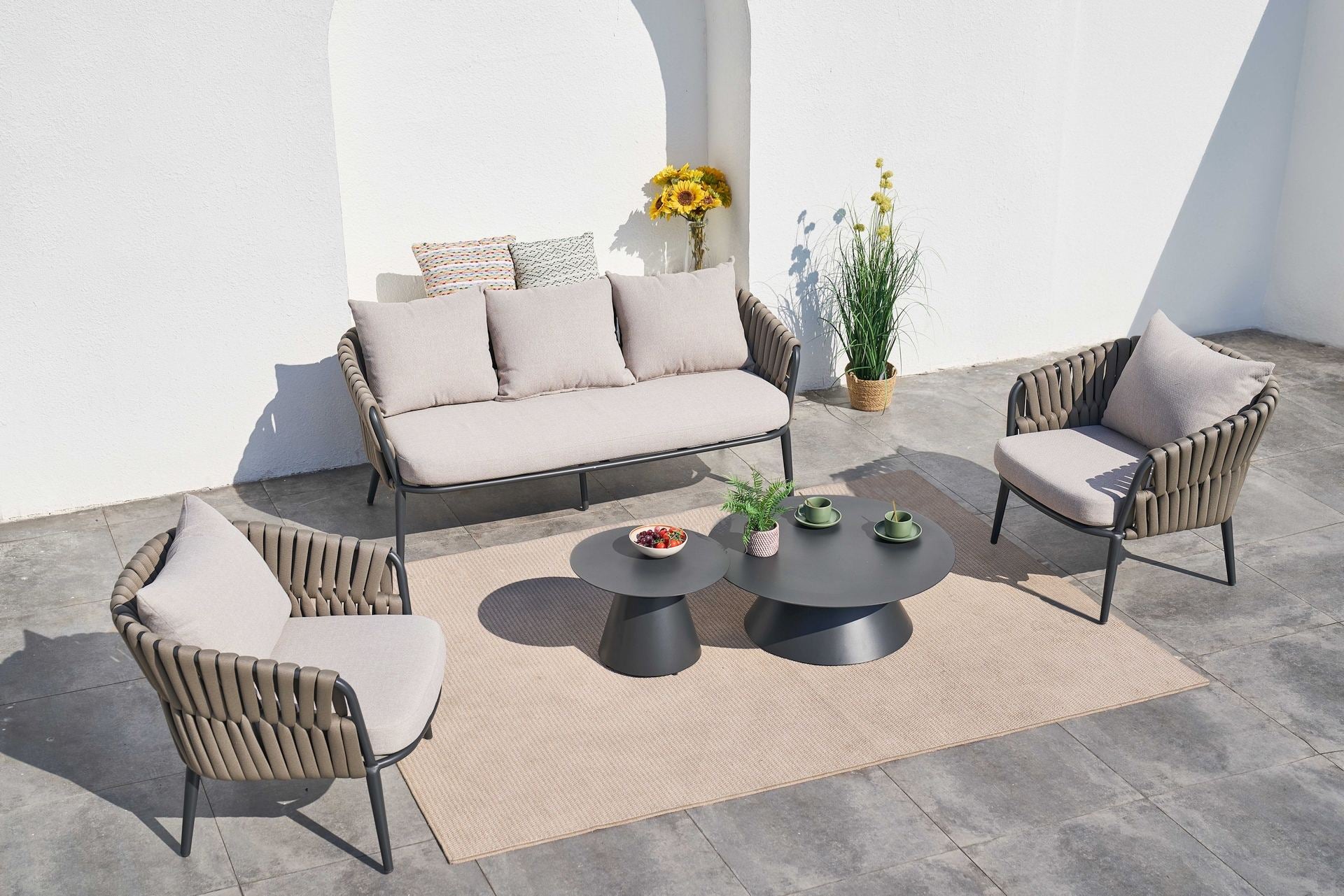 Loungegruppe Nero mit anthrazitfarbenem Aluminiumgestell, braunen Textilbändern und grauen Kissen. Moderne Outdoor-Lounge mit Couchtischen.